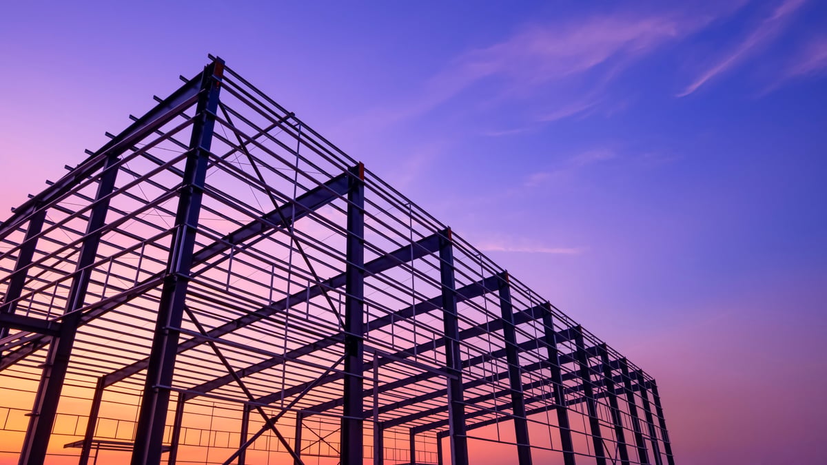 Steel framework of a warehouse building under construction at dusk